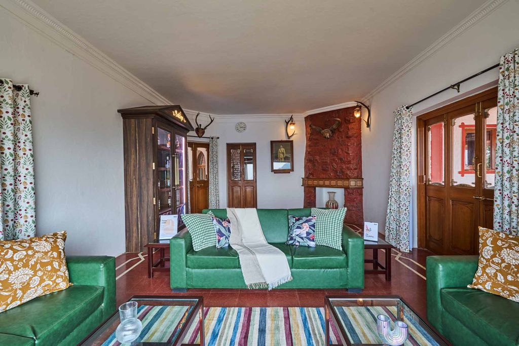 Living room with green sofas and a stone fireplace